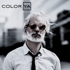 Hombre con cabello y barba blancos, gafas de sol rojas, camisa y corbata. - Luxent Professional