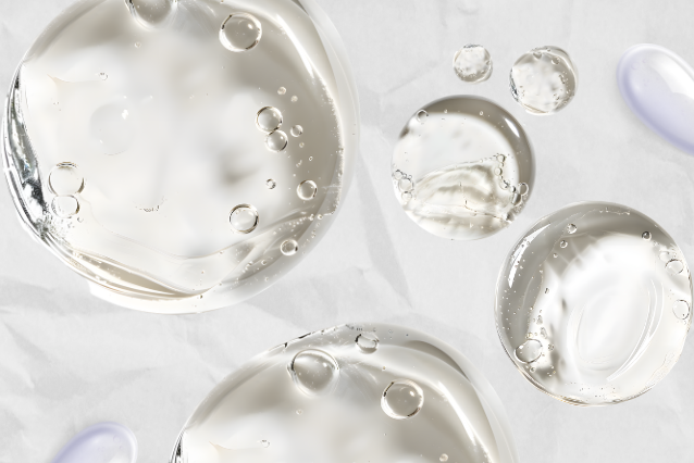Gotas de gel transparente con burbujas y reflejos morados, textura de serum L'xent Professional.