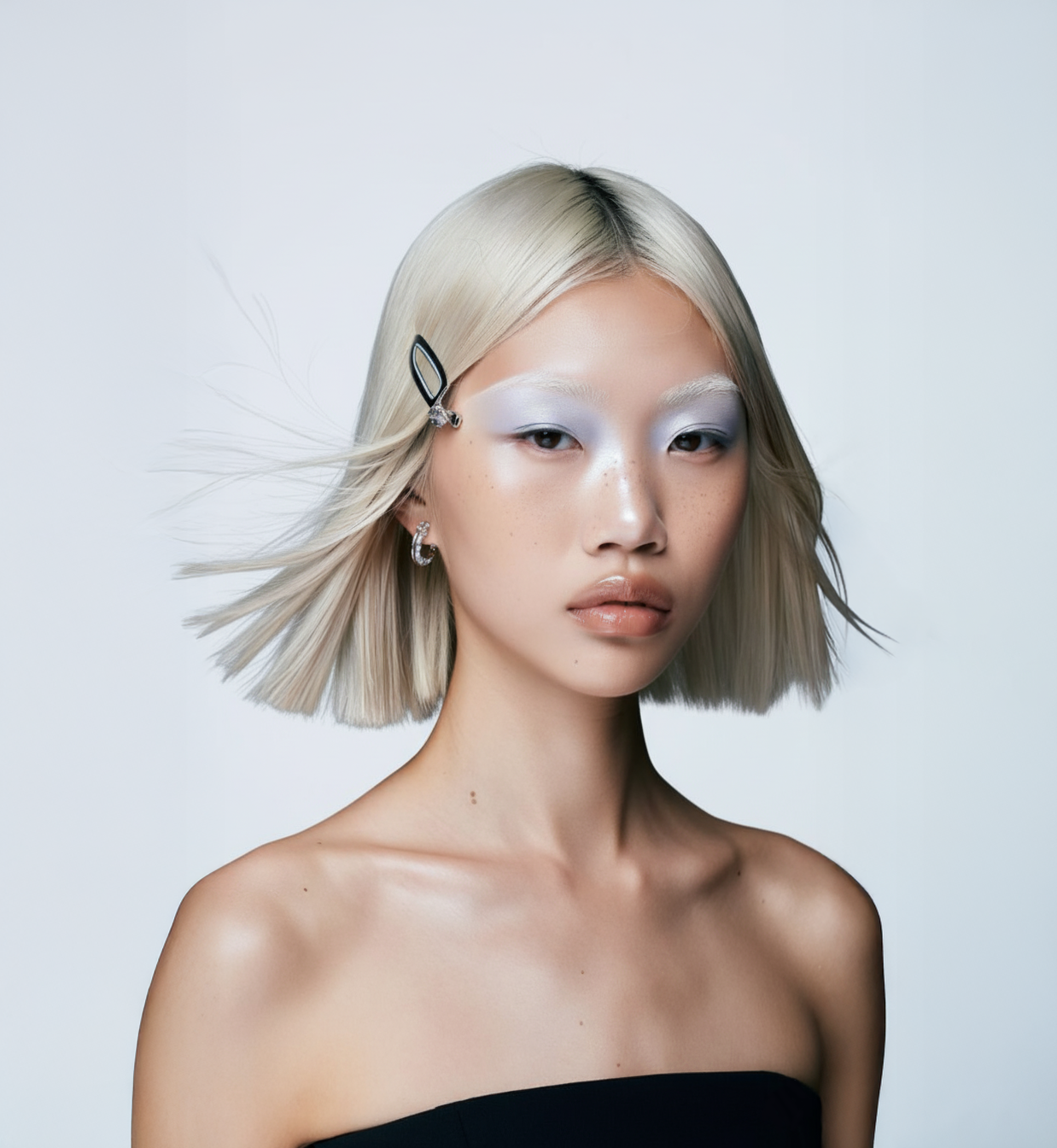 Modelo con cabello rubio platino corto y brillante, peinado con movimiento. - Luxent Professional