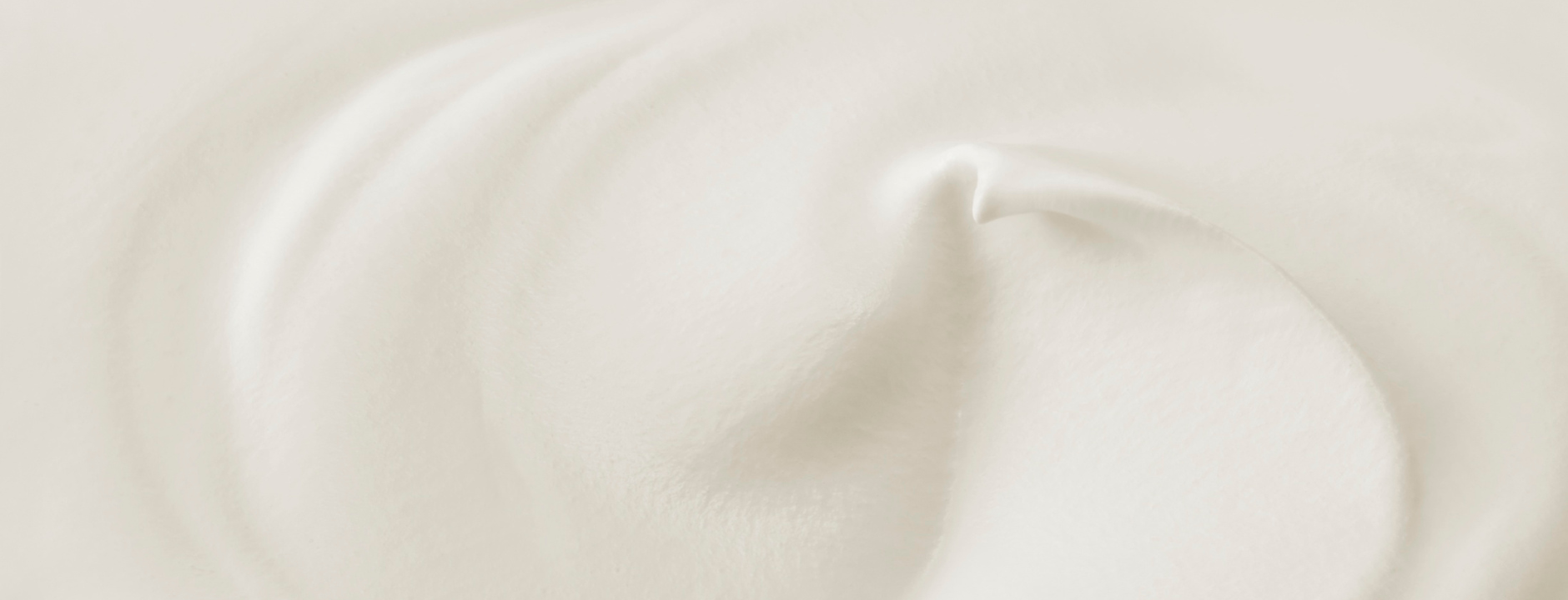 Textura cremosa blanca y suave con ondulaciones, ideal para productos capilares L'xent Professional.