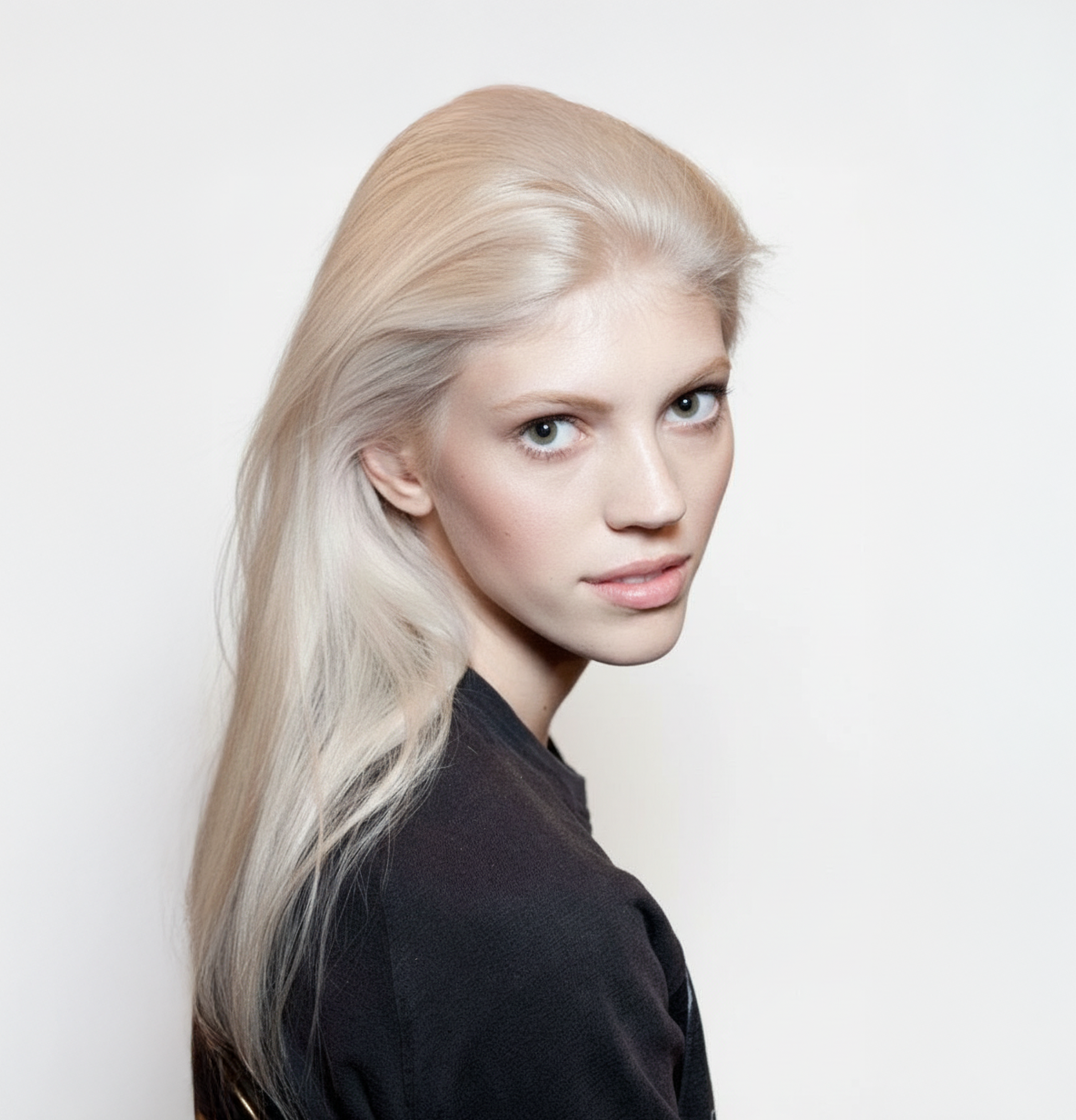 Modelo con cabello rubio platino liso y brillante, mostrando un resultado de color profesiona - Luxent Professional