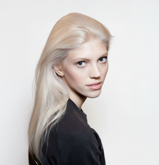 Modelo con cabello rubio platino liso y brillante, mostrando un resultado de color profesiona - Luxent Professional