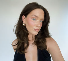 Mujer con cabello castaño oscuro ondulado y brillante, mostrando un look natural y saludable - Luxent Professional