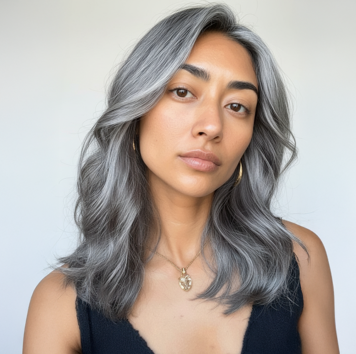 Mujer con cabello gris plateado ondulado, mostrando un look moderno y elegante. - Luxent Professional