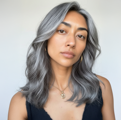 Mujer con cabello gris plateado ondulado, mostrando un look moderno y elegante. - Luxent Professional