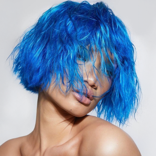 Modelo con cabello corto azul vibrante, estilo wet look. Tono fantasía de L'xent Professional.